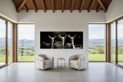 Modern living room with a large wall-mounted artwork of antelopes, surrounded by large windows with a scenic view.