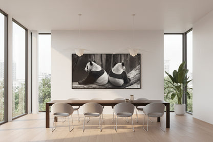 Large horizontal panda wall art displayed above dining table in modern villa with large windows and indoor plant.