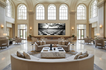 Oversized 131 × 300 cm black and white giraffe artwork mounted in a grand hotel lobby with high ceilings and arched windows.